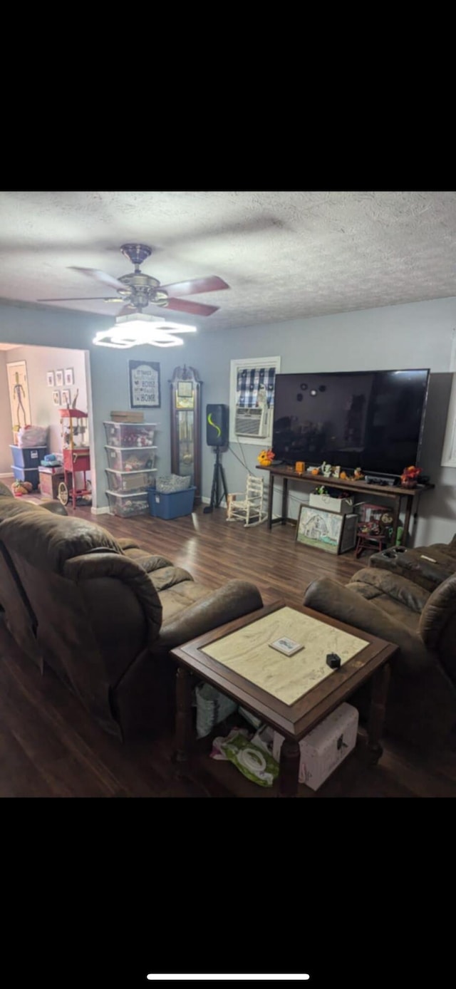 living room with hardwood / wood-style floors, ceiling fan, and a textured ceiling