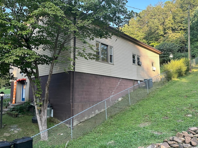 view of side of property with a lawn and central AC