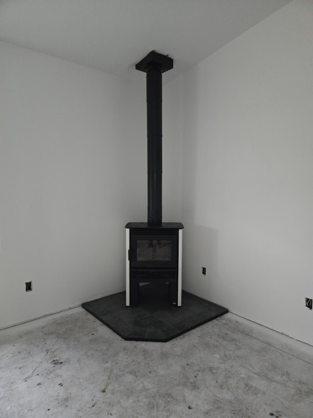 interior details with concrete flooring and a wood stove