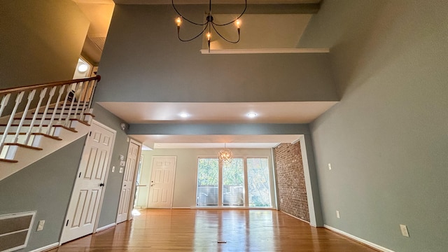 entryway featuring an inviting chandelier, a high ceiling, and hardwood / wood-style floors