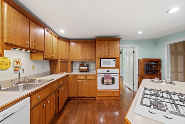 kitchen featuring white appliances, sink, and dark hardwood / wood-style floors