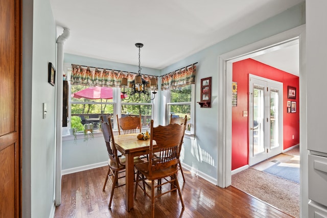 dining area with an inviting chandelier, hardwood / wood-style flooring, and a healthy amount of sunlight