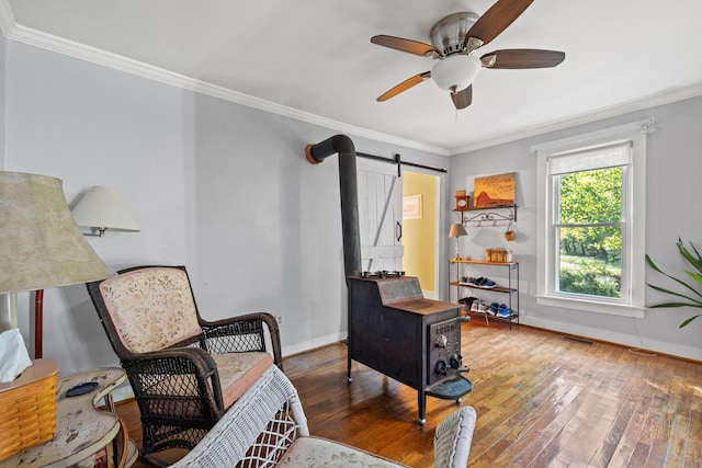 living area with ceiling fan, crown molding, a barn door, and dark hardwood / wood-style floors