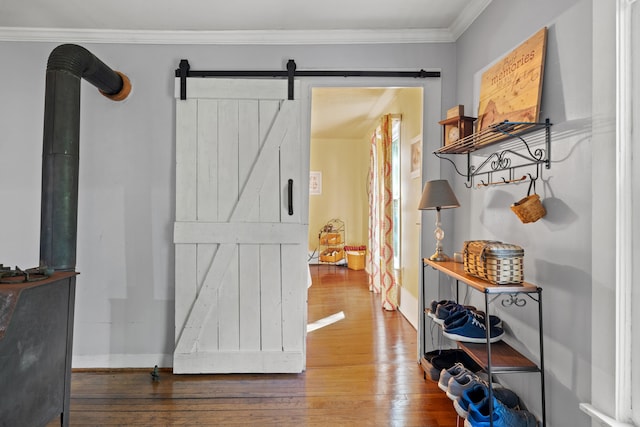 interior space with hardwood / wood-style flooring, ornamental molding, and a barn door