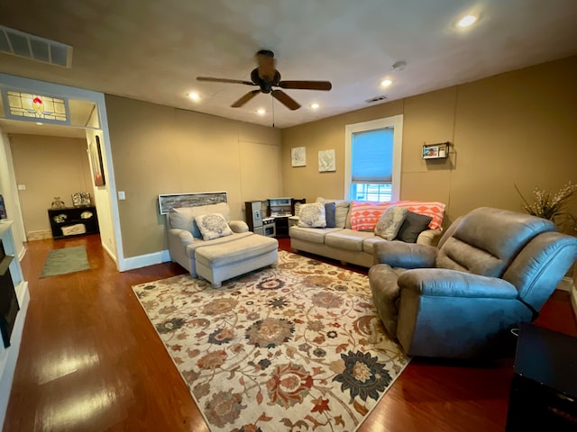 living room featuring ceiling fan and dark wood-type flooring