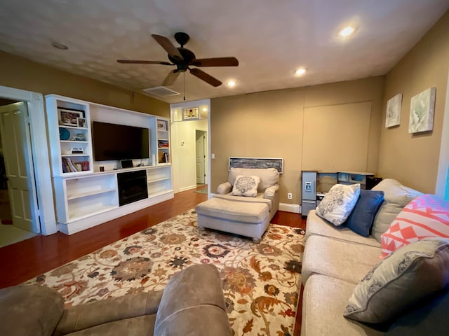 living room featuring ceiling fan and dark wood-type flooring