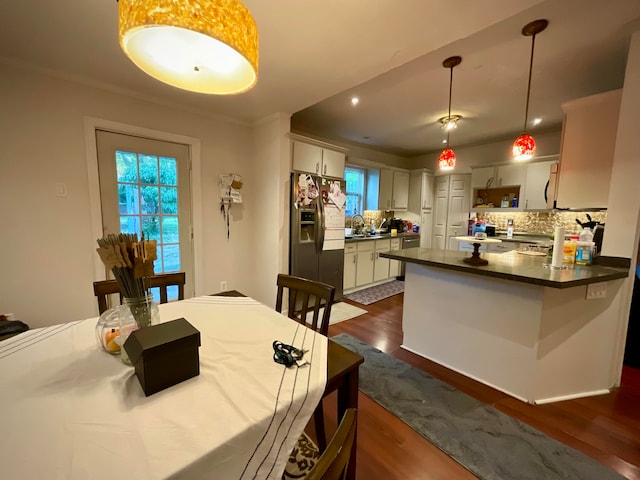 kitchen featuring backsplash, dark wood-type flooring, and stainless steel fridge with ice dispenser