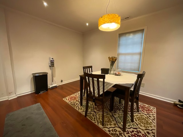 dining room featuring dark wood-type flooring and crown molding