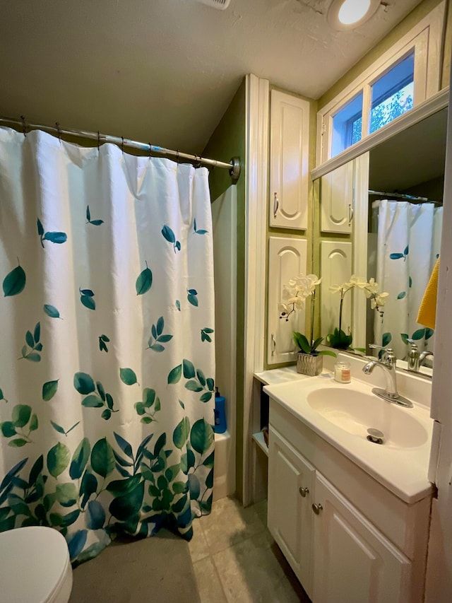 full bathroom featuring vanity, tile patterned floors, toilet, and shower / tub combo with curtain