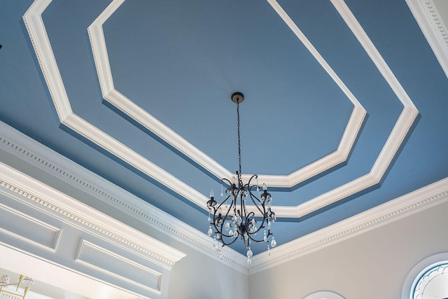 room details featuring ornamental molding, a chandelier, and a raised ceiling