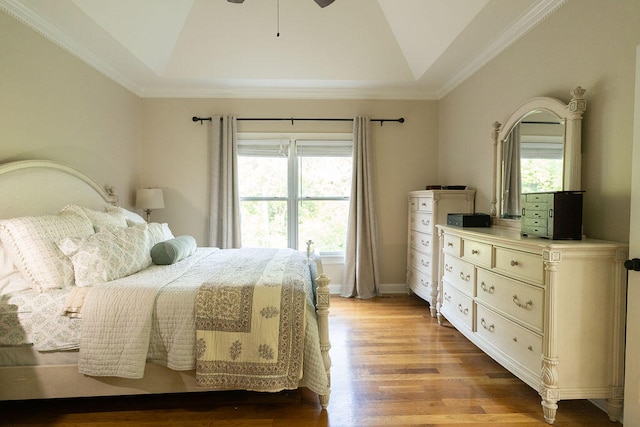 bedroom with a raised ceiling, light wood-type flooring, lofted ceiling, ceiling fan, and ornamental molding