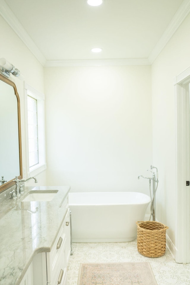 bathroom with ornamental molding, a tub to relax in, and vanity