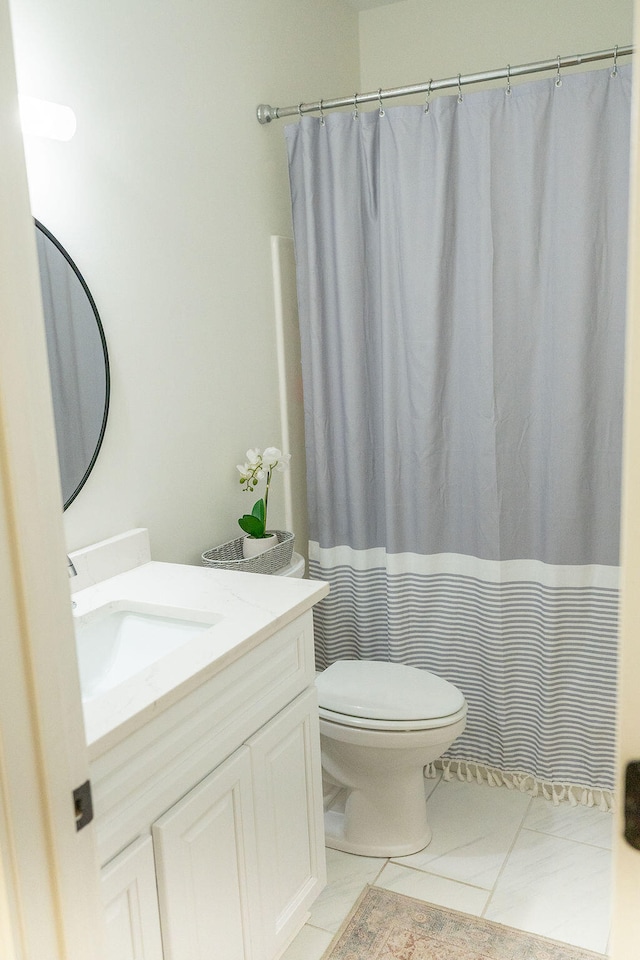 bathroom with a shower with shower curtain, tile patterned floors, vanity, and toilet