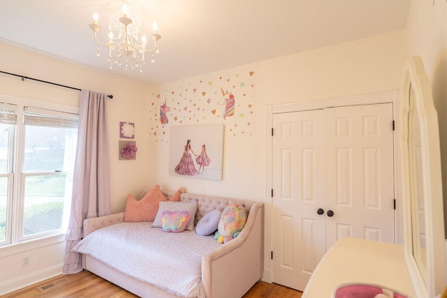 bedroom with a closet, light wood-type flooring, and multiple windows