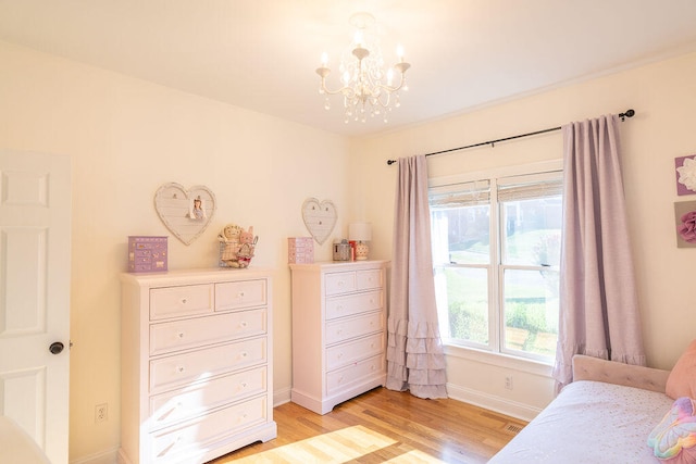 bedroom featuring light wood-type flooring and a chandelier