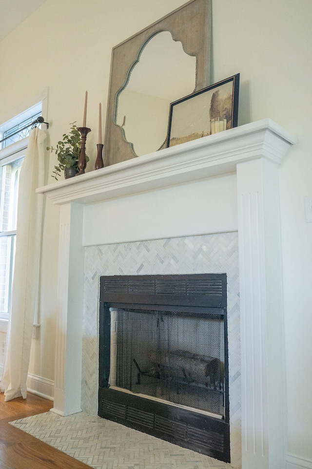 details with a tiled fireplace and hardwood / wood-style flooring