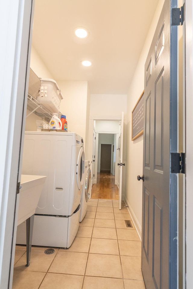 washroom featuring separate washer and dryer and light tile patterned floors