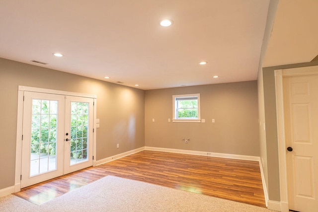 empty room with light wood-type flooring and french doors