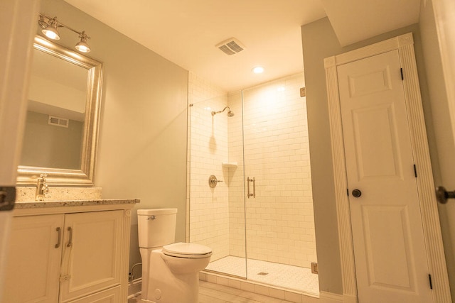 bathroom featuring a shower with door, toilet, and vanity