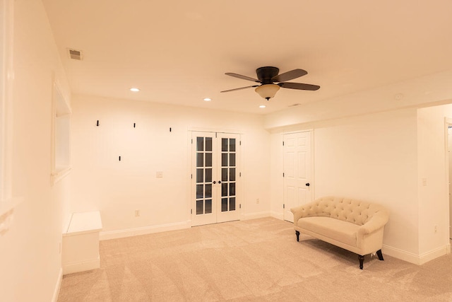 sitting room featuring ceiling fan, light carpet, and french doors