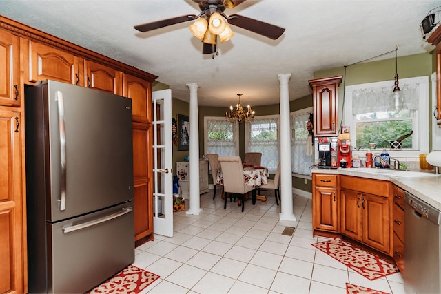 kitchen featuring hanging light fixtures, sink, stainless steel appliances, and ornate columns