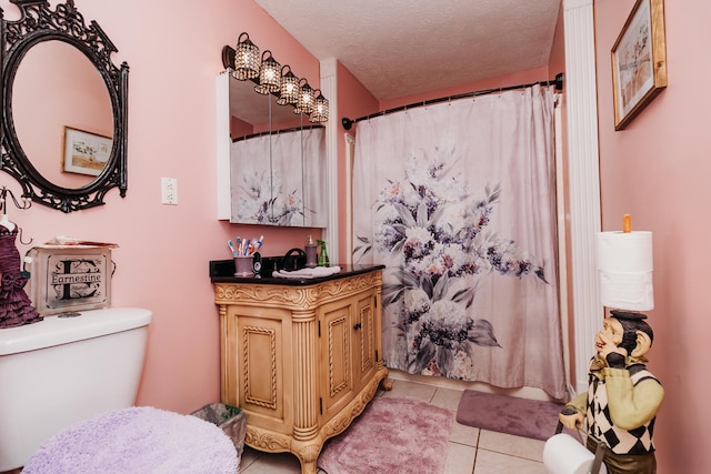 bathroom with tile patterned floors, a textured ceiling, vanity, and toilet