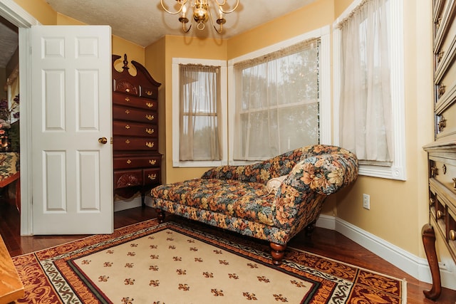 sitting room featuring an inviting chandelier, a textured ceiling, and hardwood / wood-style floors