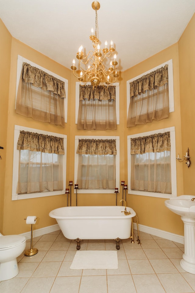 bathroom with a bath, tile patterned flooring, toilet, and a wealth of natural light