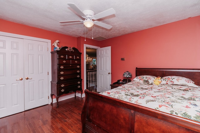 bedroom featuring a textured ceiling, dark wood-type flooring, ceiling fan, and a closet