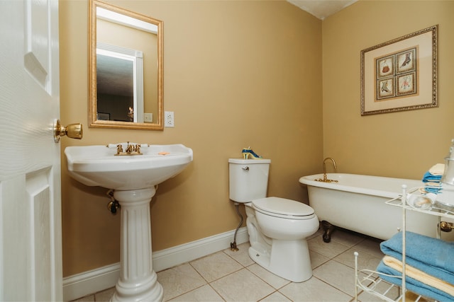 bathroom with tile patterned flooring, sink, a tub, and toilet