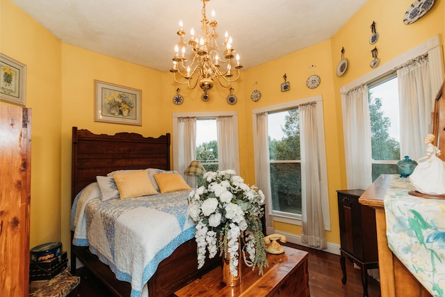 bedroom featuring an inviting chandelier, multiple windows, and dark hardwood / wood-style flooring