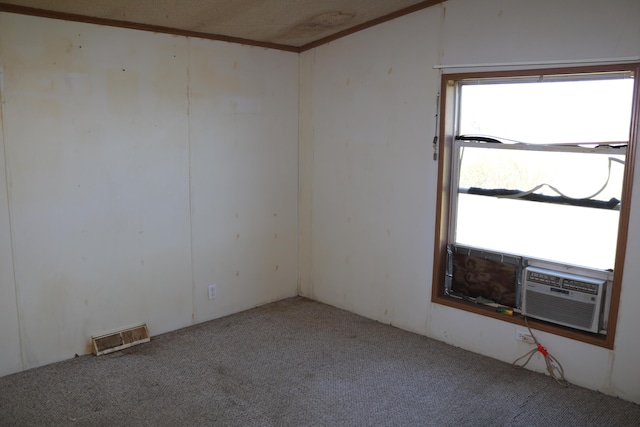 carpeted spare room featuring cooling unit and a textured ceiling