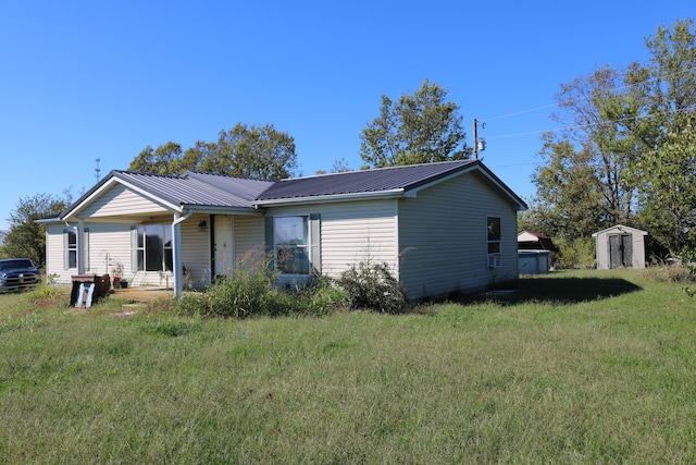 view of front facade with a storage shed and a front lawn