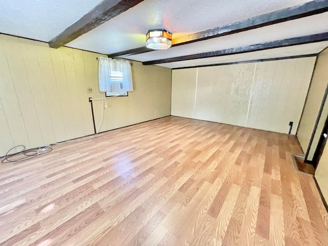 basement featuring wood walls and light hardwood / wood-style floors