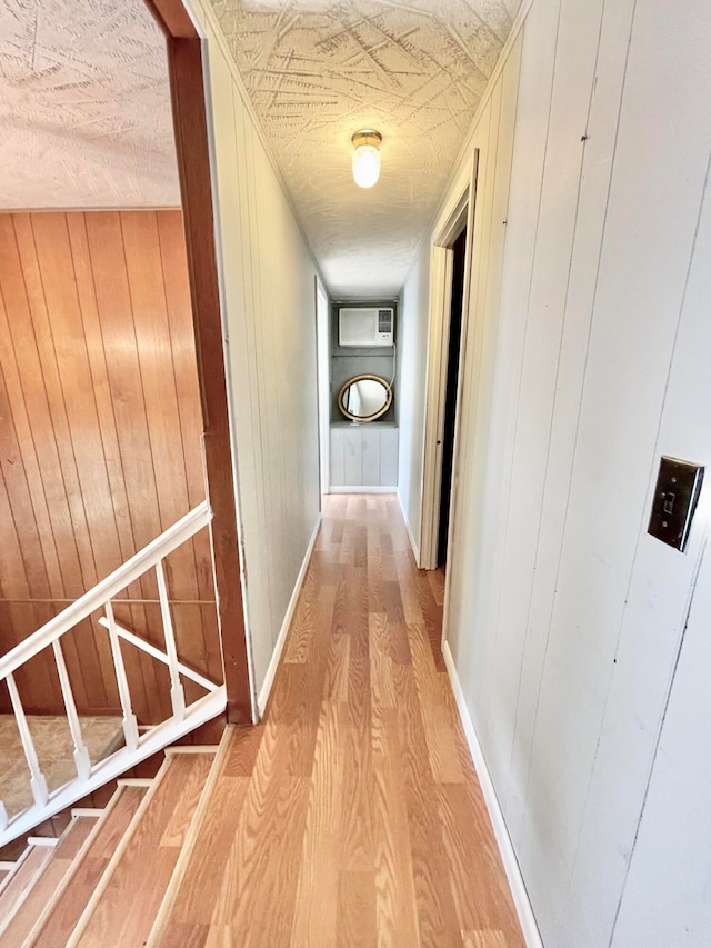 hallway with wood walls and hardwood / wood-style floors