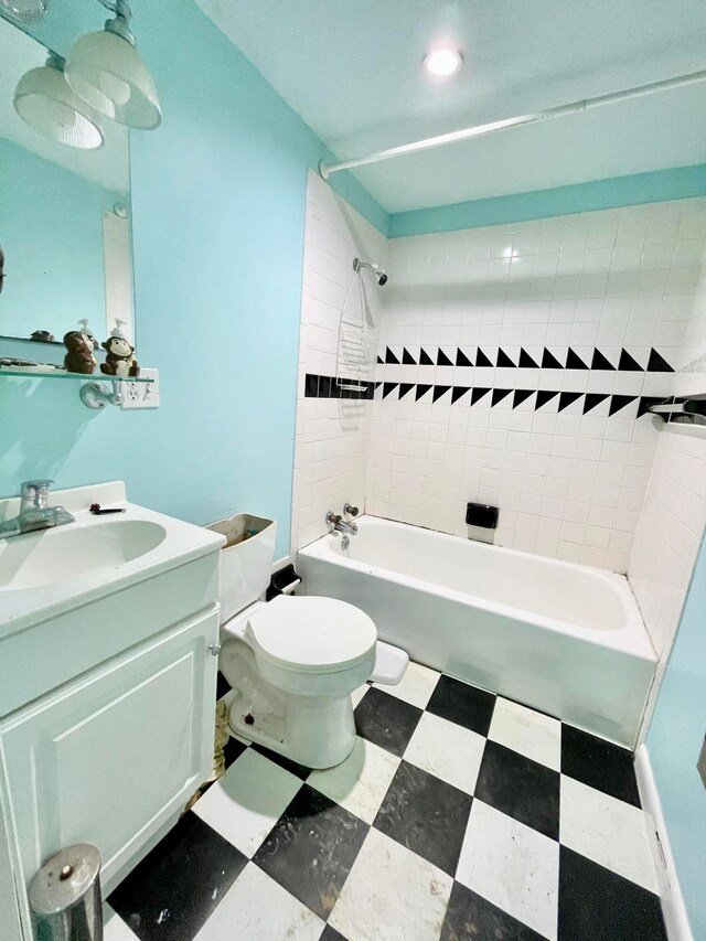 full bathroom featuring tiled shower / bath combo, vanity, and toilet