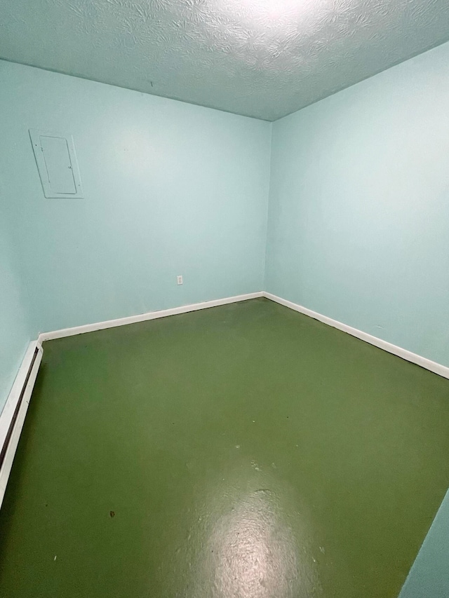 spare room with a baseboard radiator, a textured ceiling, and concrete floors