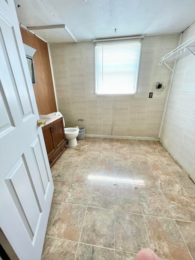 bathroom with a tile shower, vanity, and toilet