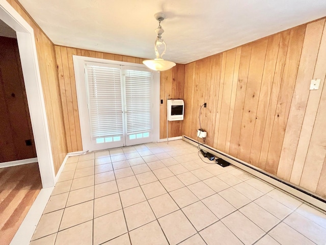 unfurnished room featuring a baseboard radiator, wooden walls, heating unit, and light tile patterned flooring