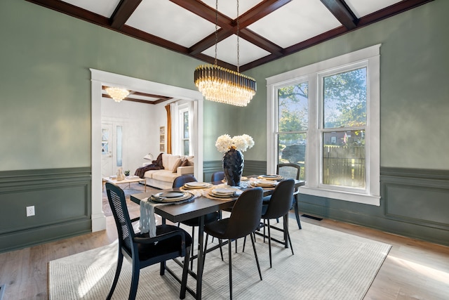 dining space with beam ceiling, a chandelier, coffered ceiling, and light wood-type flooring