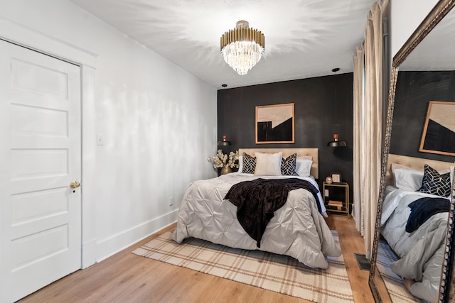 bedroom with hardwood / wood-style floors and a chandelier