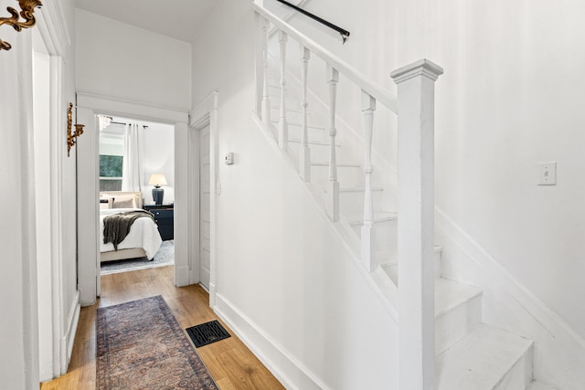 stairs featuring hardwood / wood-style floors