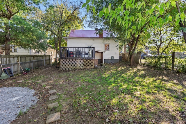 back of property with a lawn and a wooden deck