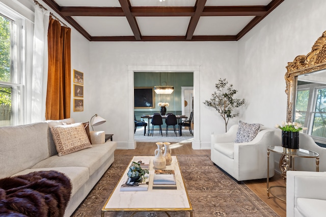 living room with a chandelier, beam ceiling, wood-type flooring, and coffered ceiling