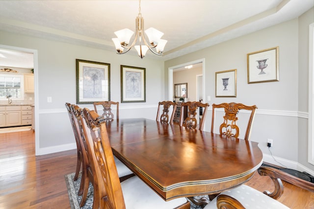 dining area with wood-type flooring and a chandelier