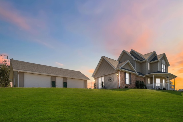 view of front of property with a lawn, a porch, and a garage