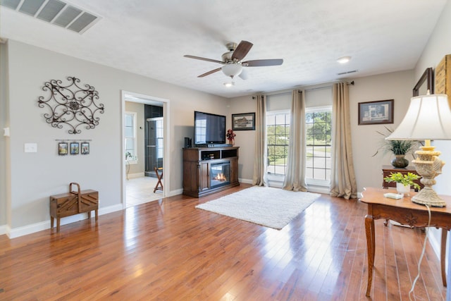 living room featuring ceiling fan and hardwood / wood-style floors