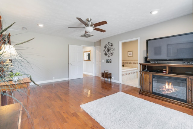 living room featuring ceiling fan and hardwood / wood-style flooring