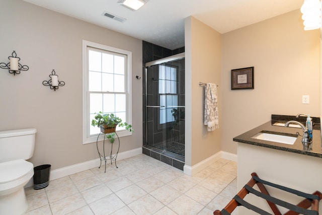 bathroom featuring vanity, toilet, a shower with door, and tile patterned floors