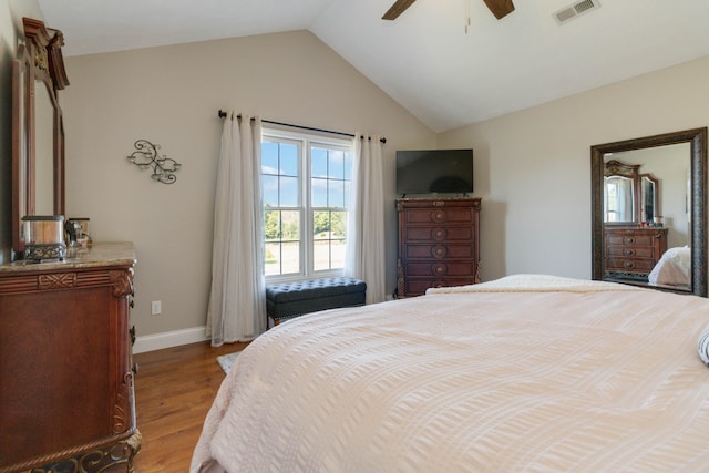 bedroom featuring light hardwood / wood-style floors, vaulted ceiling, and ceiling fan